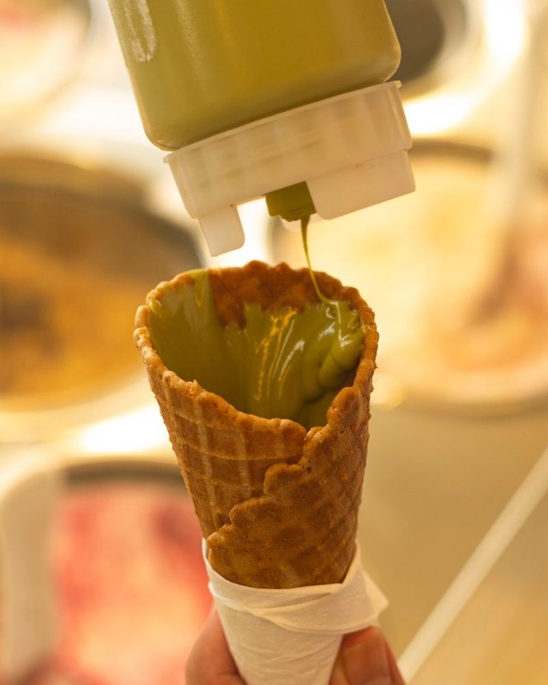 Casquinha sendo recheada com creme de pistache